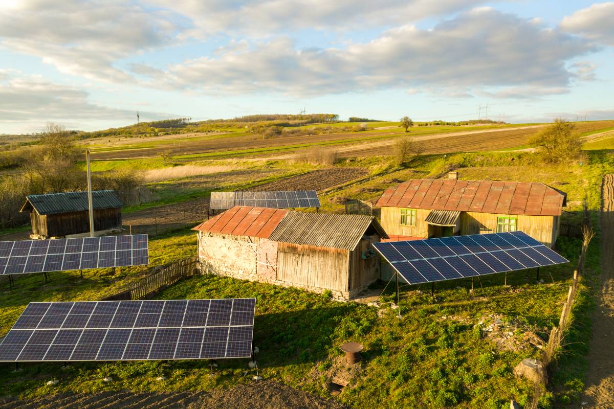 Aerial top down view of solar panels in green rural village yard.
